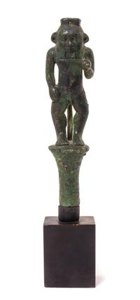 An Egyptian Bronze Bes Standing on a Papyrus Umbel Height 7 inches. — THIRD INTERMEDIATE PERIOD, DYNASTY 21-22, 1070-712 B.C.E.