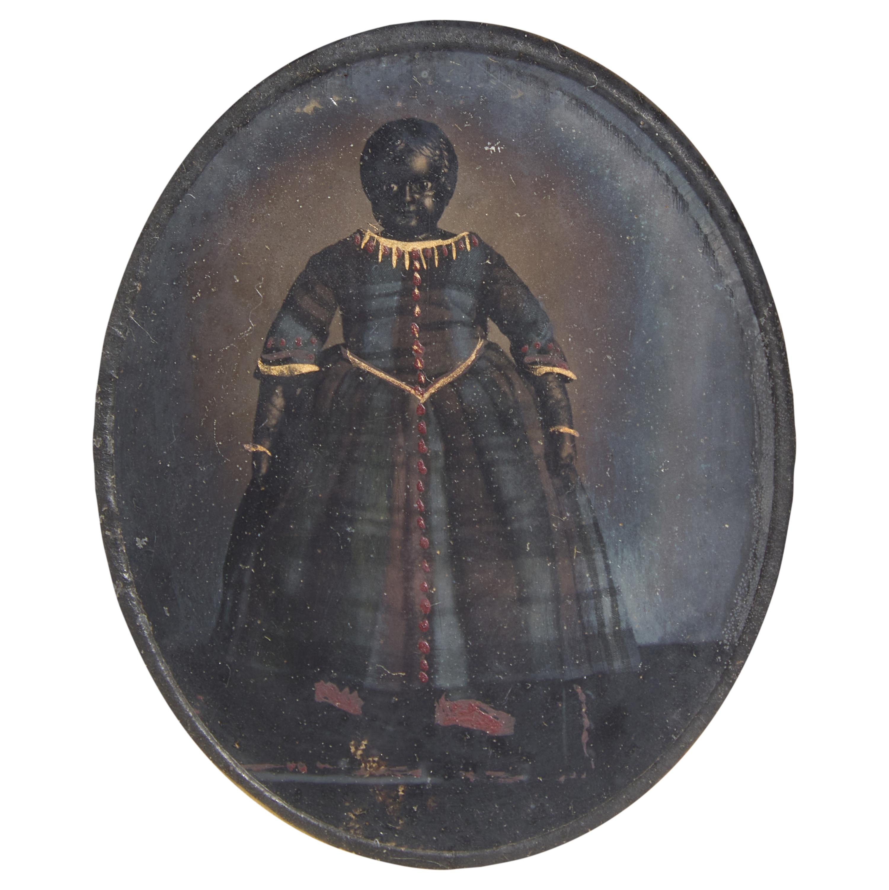 An Ambrotype of A Black Doll in a Plaid Dress With Painted and Gilt Highlights