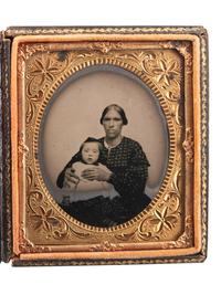 [EARLY PHOTOGRAPHY]. Sixth plate ruby ambrotype of an African American or mixed race woman holding a white child.