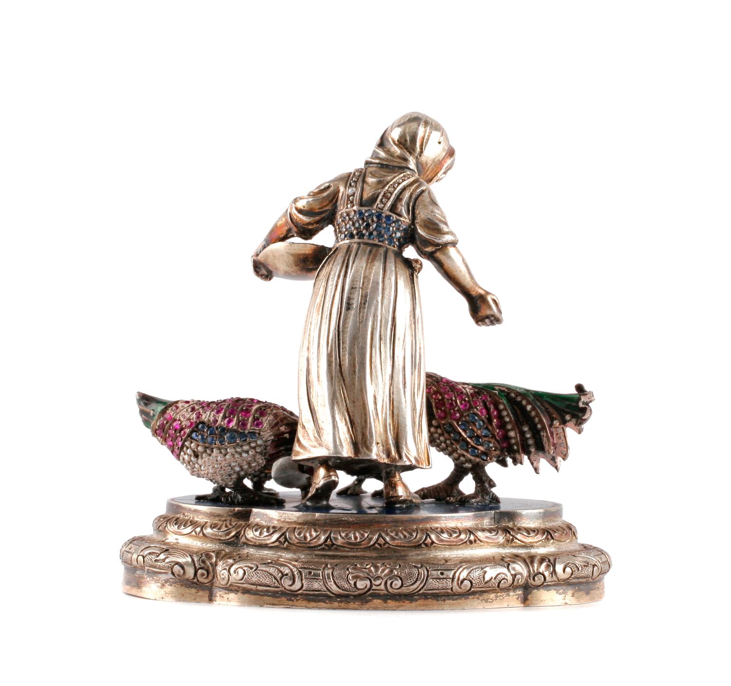 A Continental Ruby Mounted Silver and Enamel Figure, , in the form of a peasant woman feeding three birds.