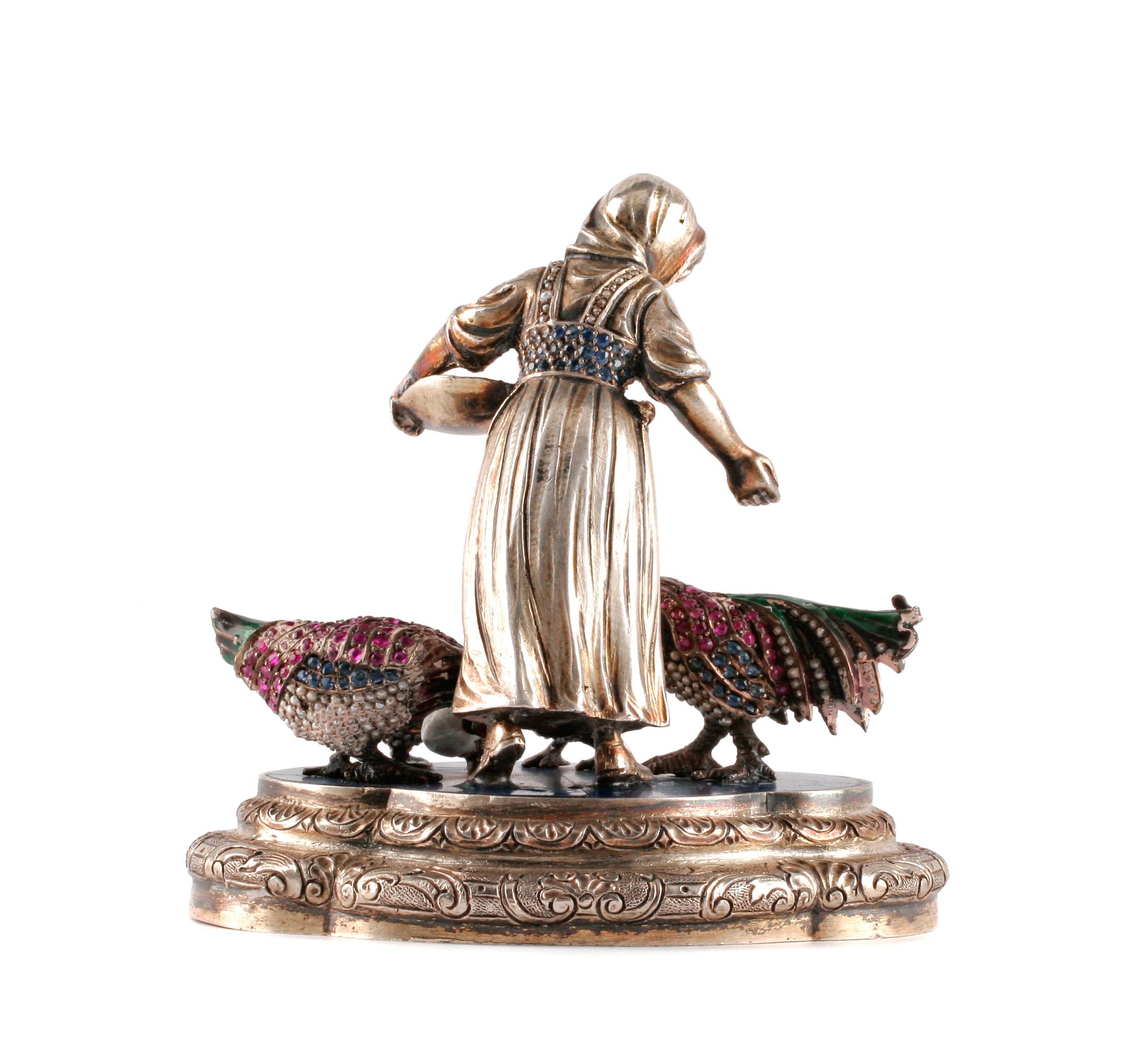 A Continental Ruby Mounted Silver and Enamel Figure, , in the form of a peasant woman feeding three birds.