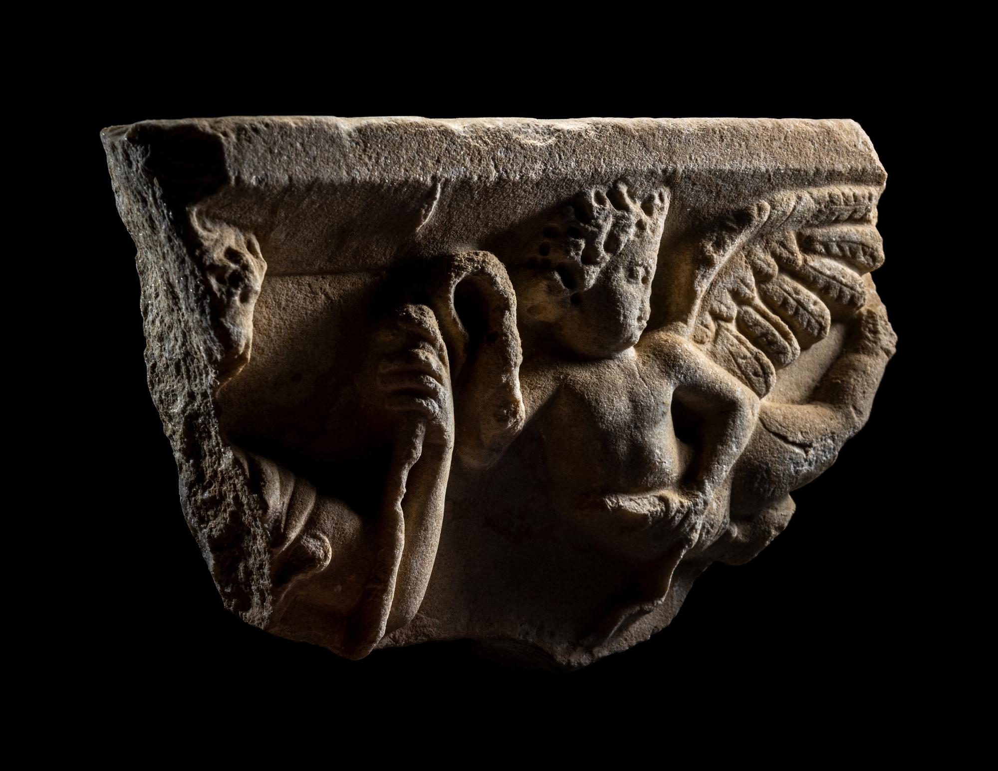 A Roman Marble Sarcophagus Fragment with Eros Holding Snakes