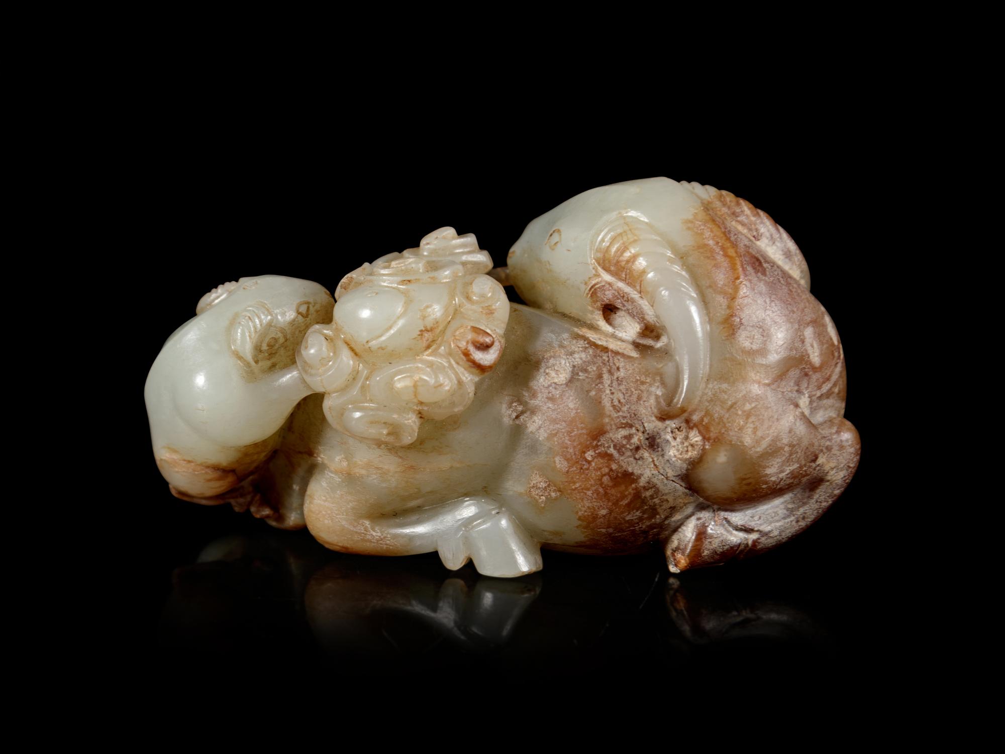 A Carved Celadon and Russet Jade 'Three Rams' Group