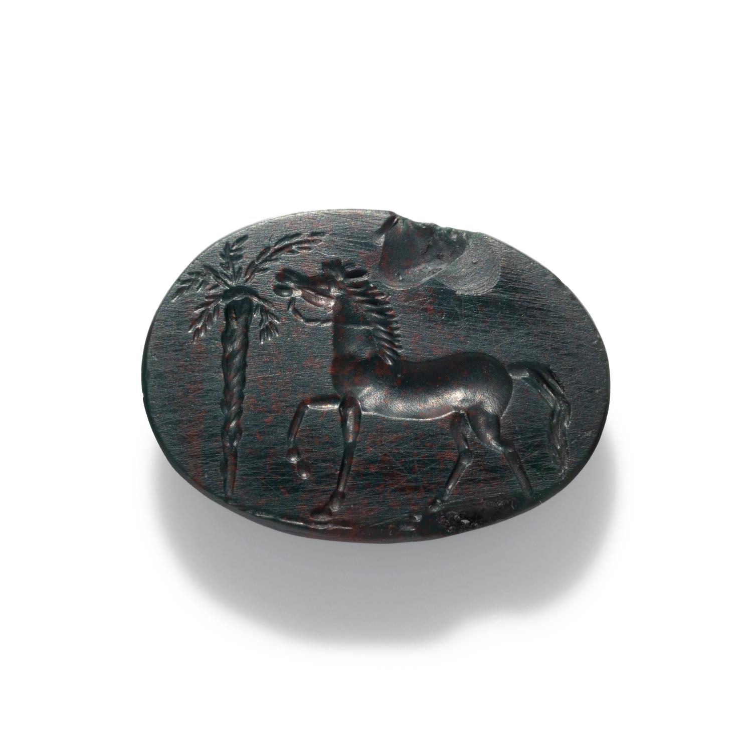 A Roman Bloodstone Ring Stone with a Horse and Palm Tree