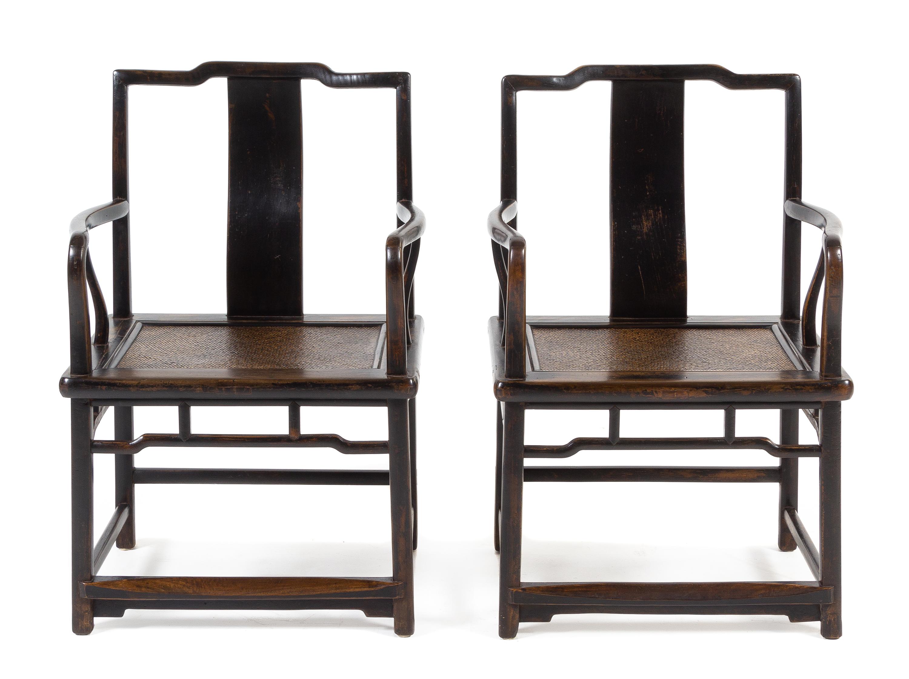 A Pair of Chinese Black Lacquered Elmwood Official's Hat Armchairs, Nanguanmaoyi Height 34 x width 23 1/8 x depth 18 inches. — QING DYNASTY (1644-1911)