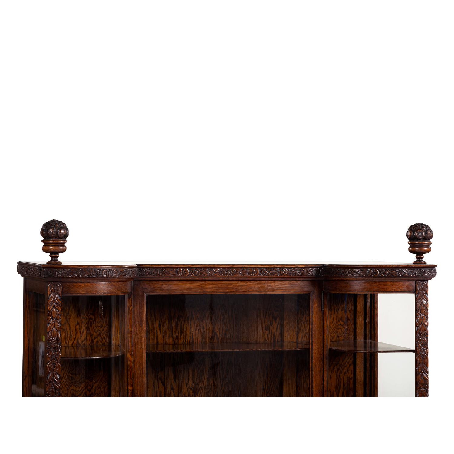 A Carved Oak Vitrine Cabinet and Open Bookshelf
