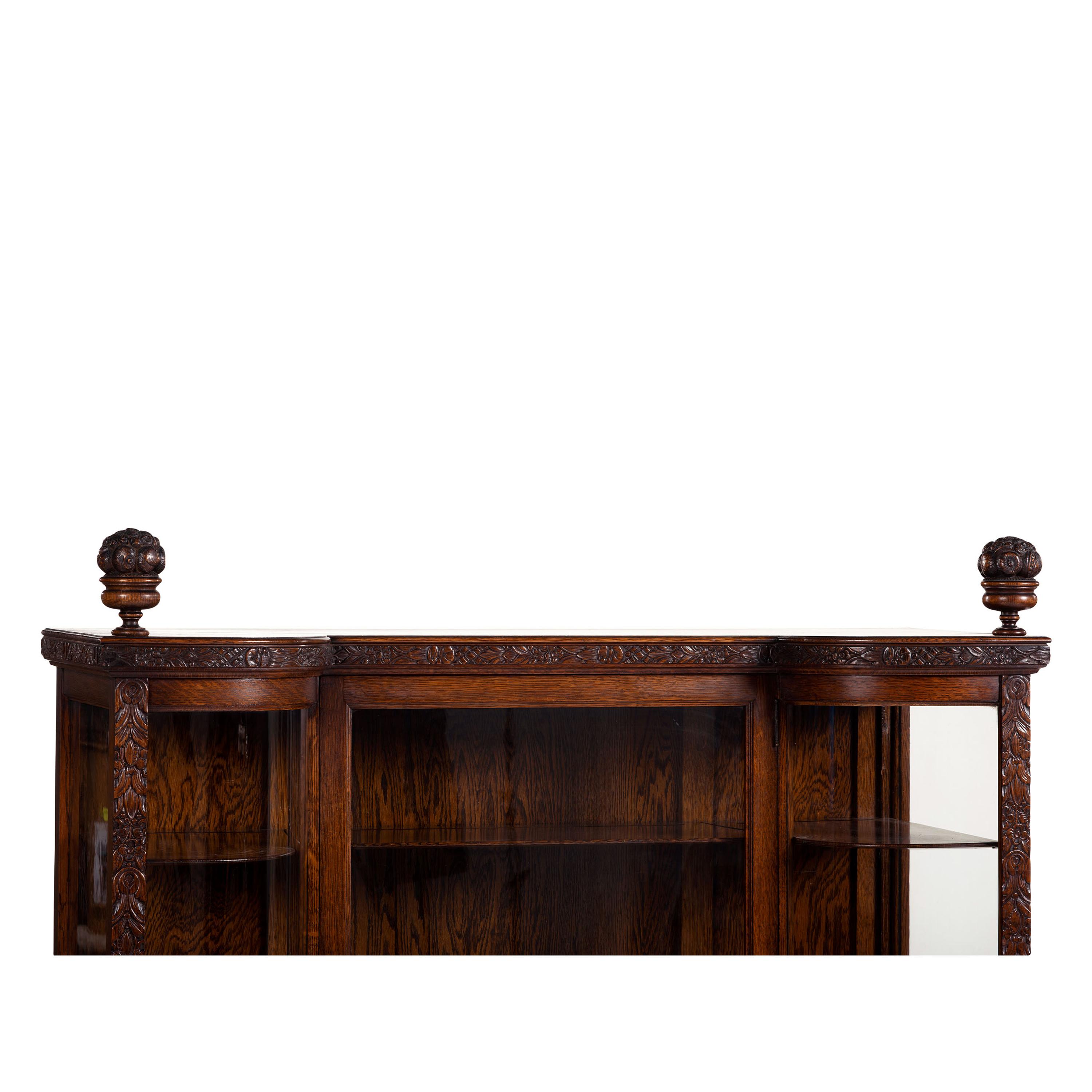 A Carved Oak Vitrine Cabinet and Open Bookshelf