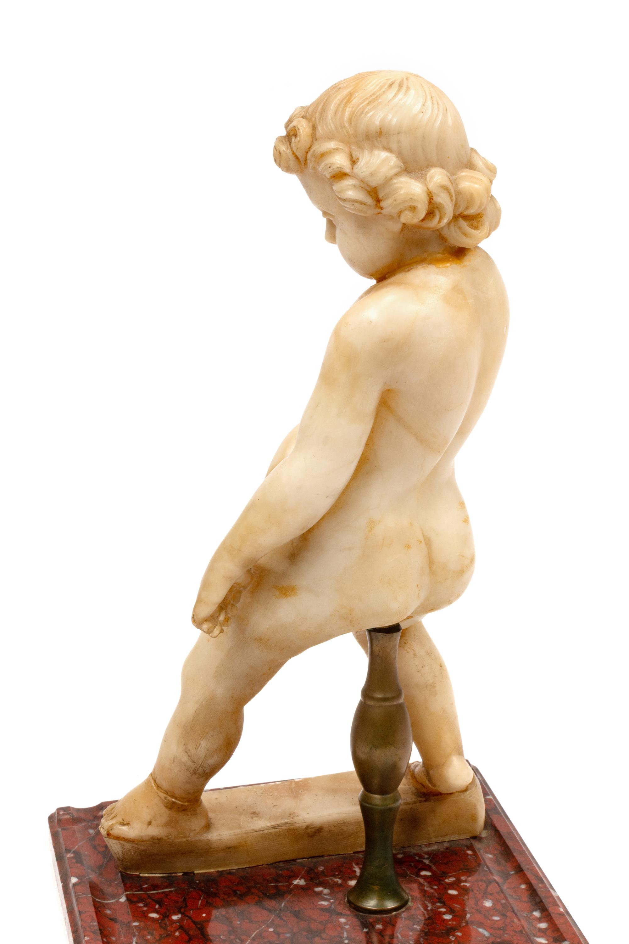 A Continental Carved Marble Figure of a Putto on a Red Marble Base