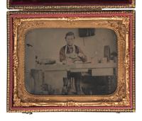 [EARLY PHOTOGRAPHY]. Hand-colored quarter plate ambrotype of a cobbler at work in his shop. [New York]: [Bogardus], n.d.
