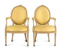 A Pair of George III Carved, Grey-Painted and Parcel Gilt Armchairs