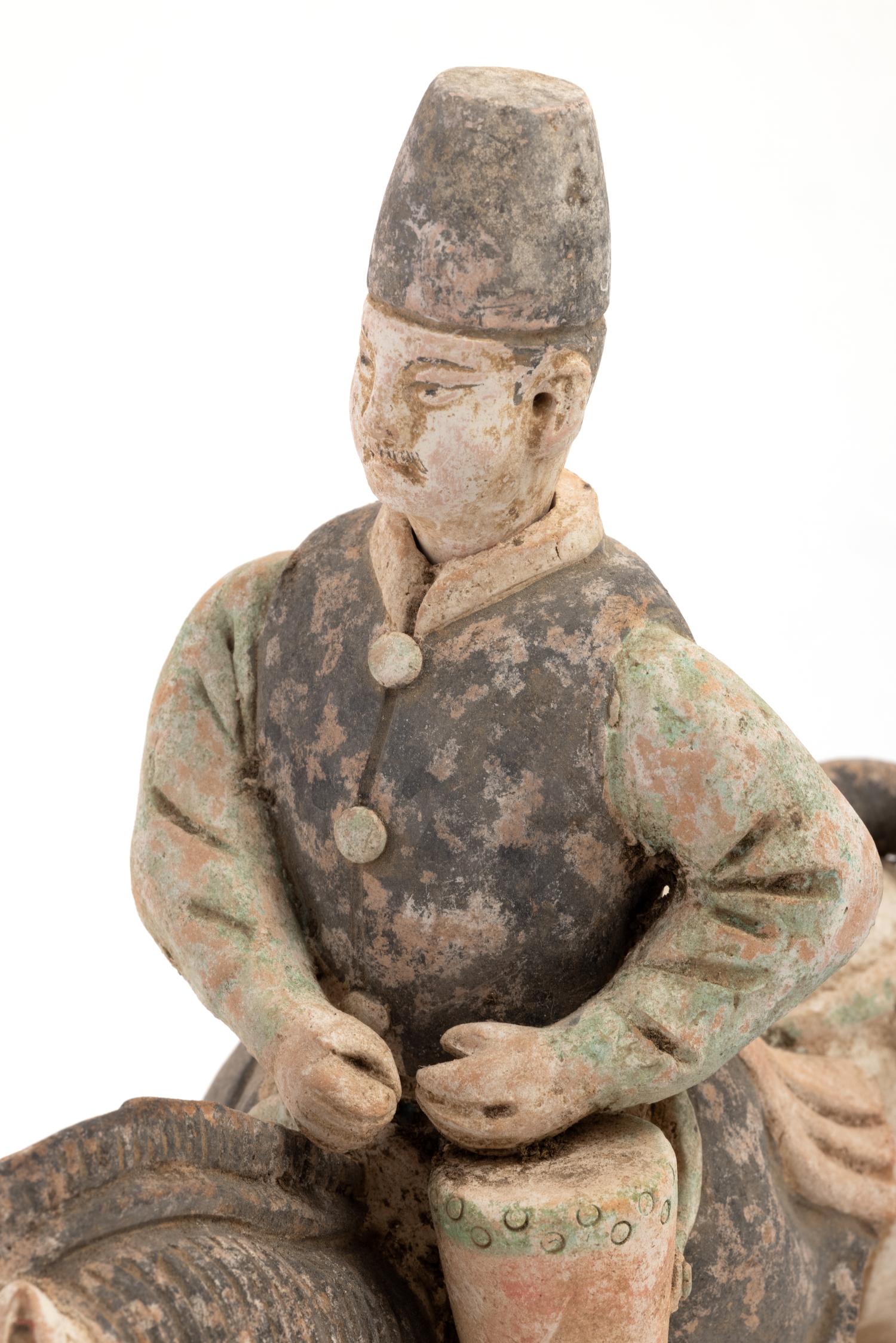 A Chinese Painted Terra Cotta Burial Figure of a Mounted Attendant