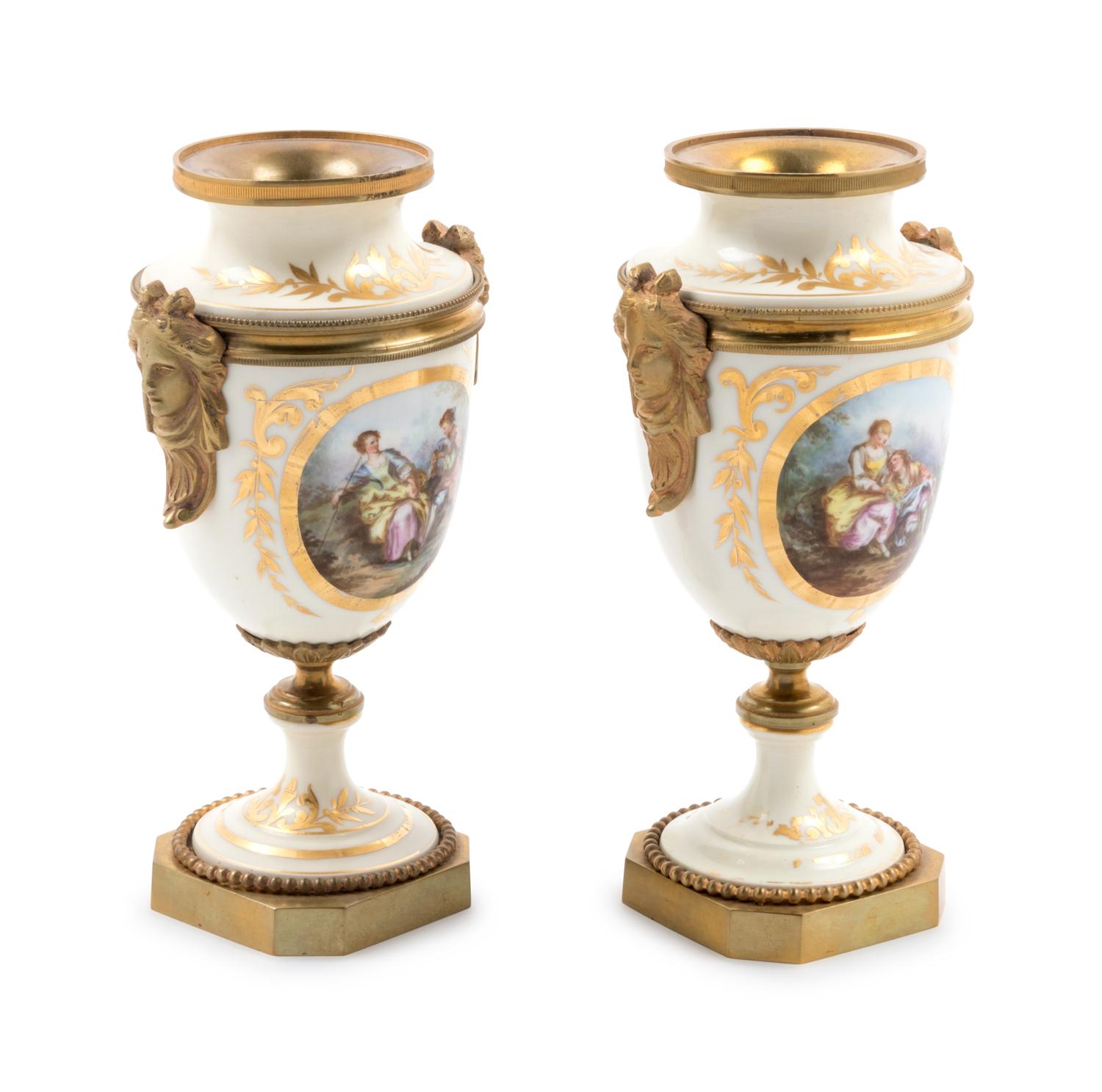 A Pair of Sèvres Style Gilt Bronze Mounted Painted and Parcel Gilt Porcelain Urns