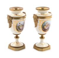 A Pair of Sèvres Style Gilt Bronze Mounted Painted and Parcel Gilt Porcelain Urns