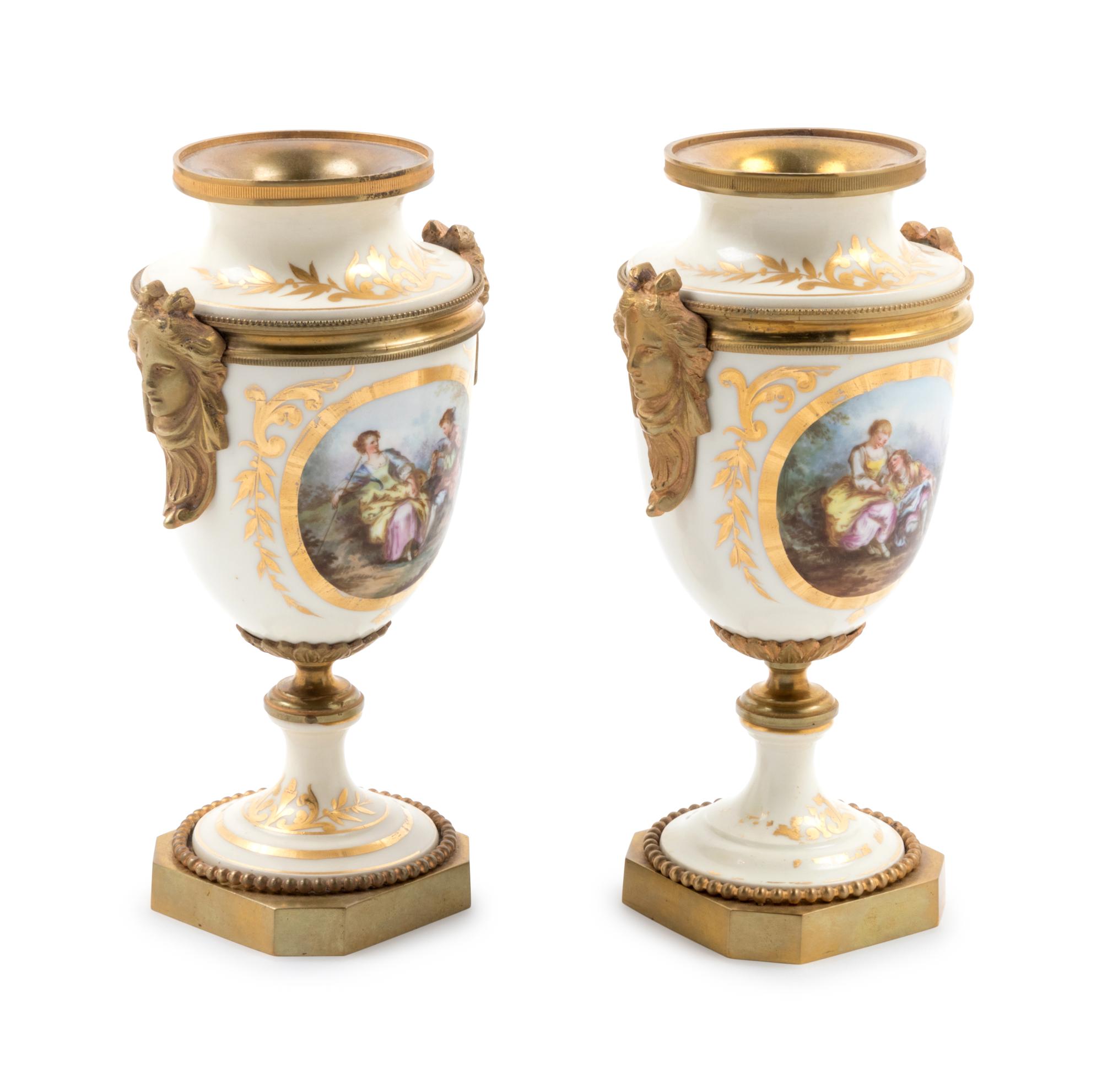 A Pair of Sèvres Style Gilt Bronze Mounted Painted and Parcel Gilt Porcelain Urns