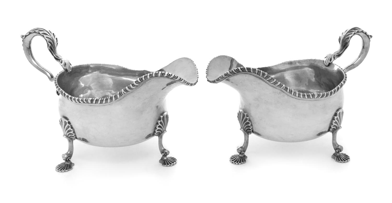 A Pair of George III Silver Sauce Boats, Thomas Heming, London, 1774, each having a gadrooned rim and a leaf-capped handle, raised on t