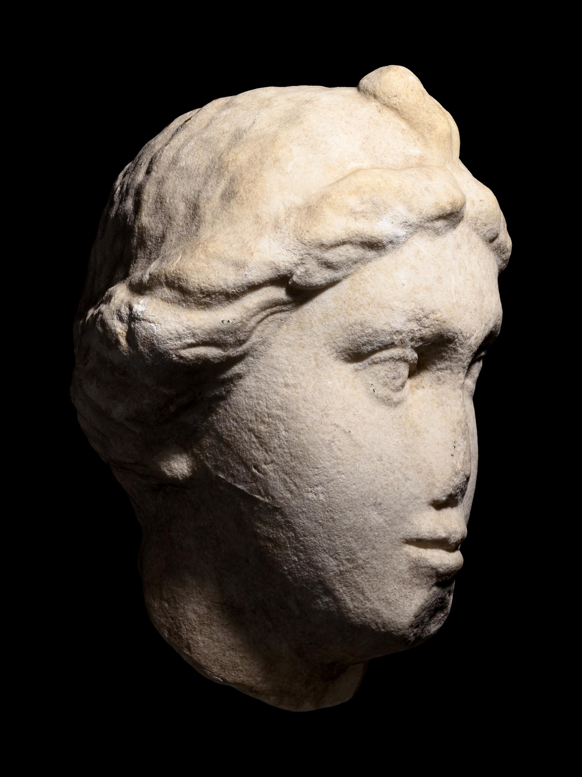 A Roman Marble Head of a Woman with Plaited Hair and Ribbon
