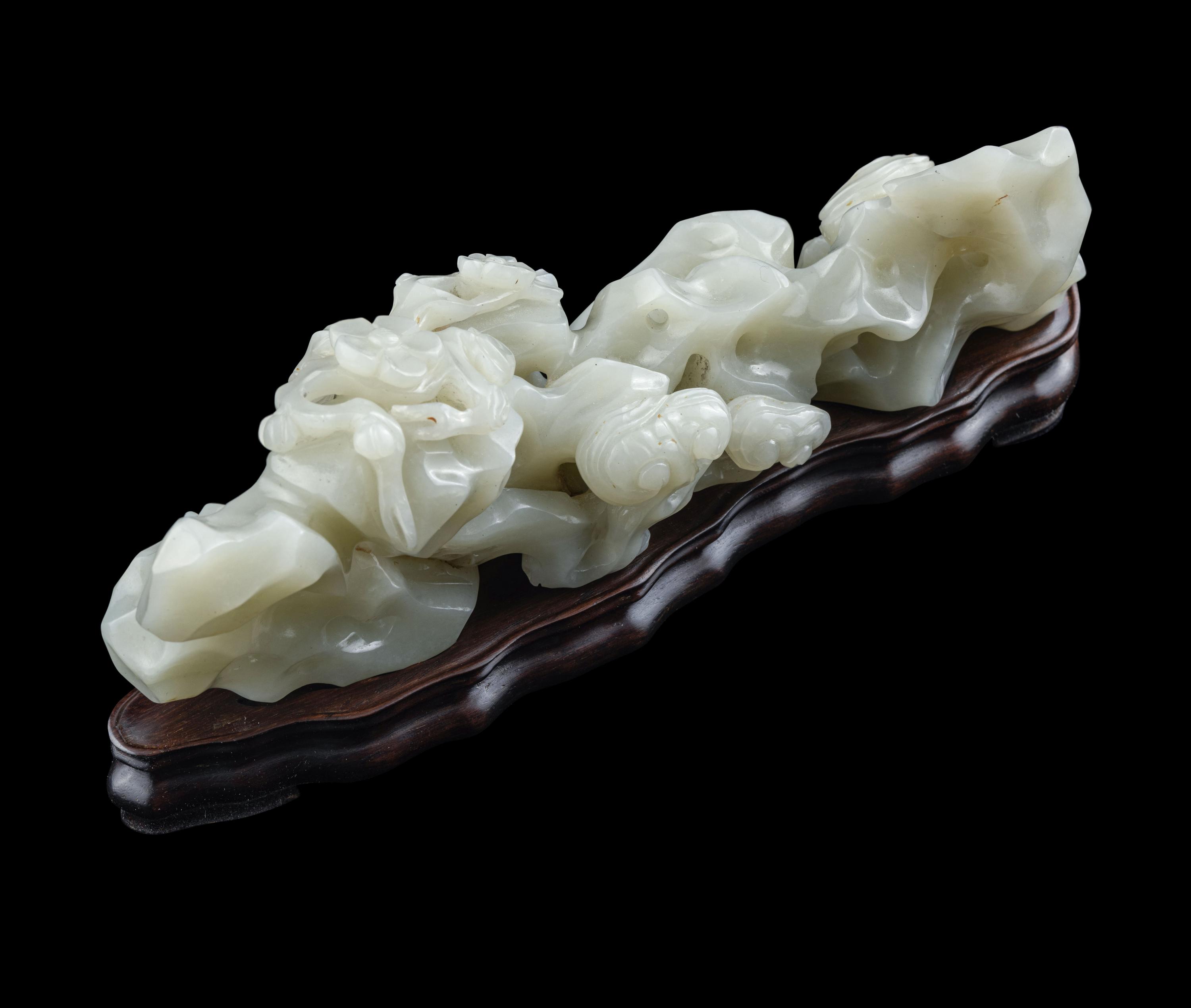 A Chinese Pale Celadon Jade ‘Lingzhi and Rockwork’ Brush Rest, 20th Century — 近代 青白玉靈芝筆架