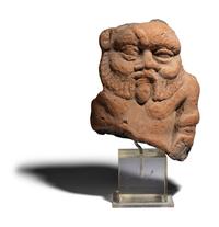 An Egyptian Terracotta Head of Bes
