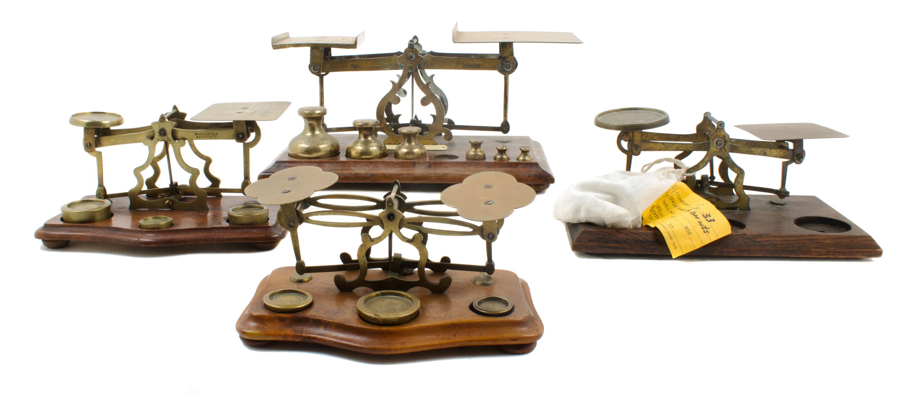 A Group of Four Brass Postal Scales and Weights Width of largest 11 inches.