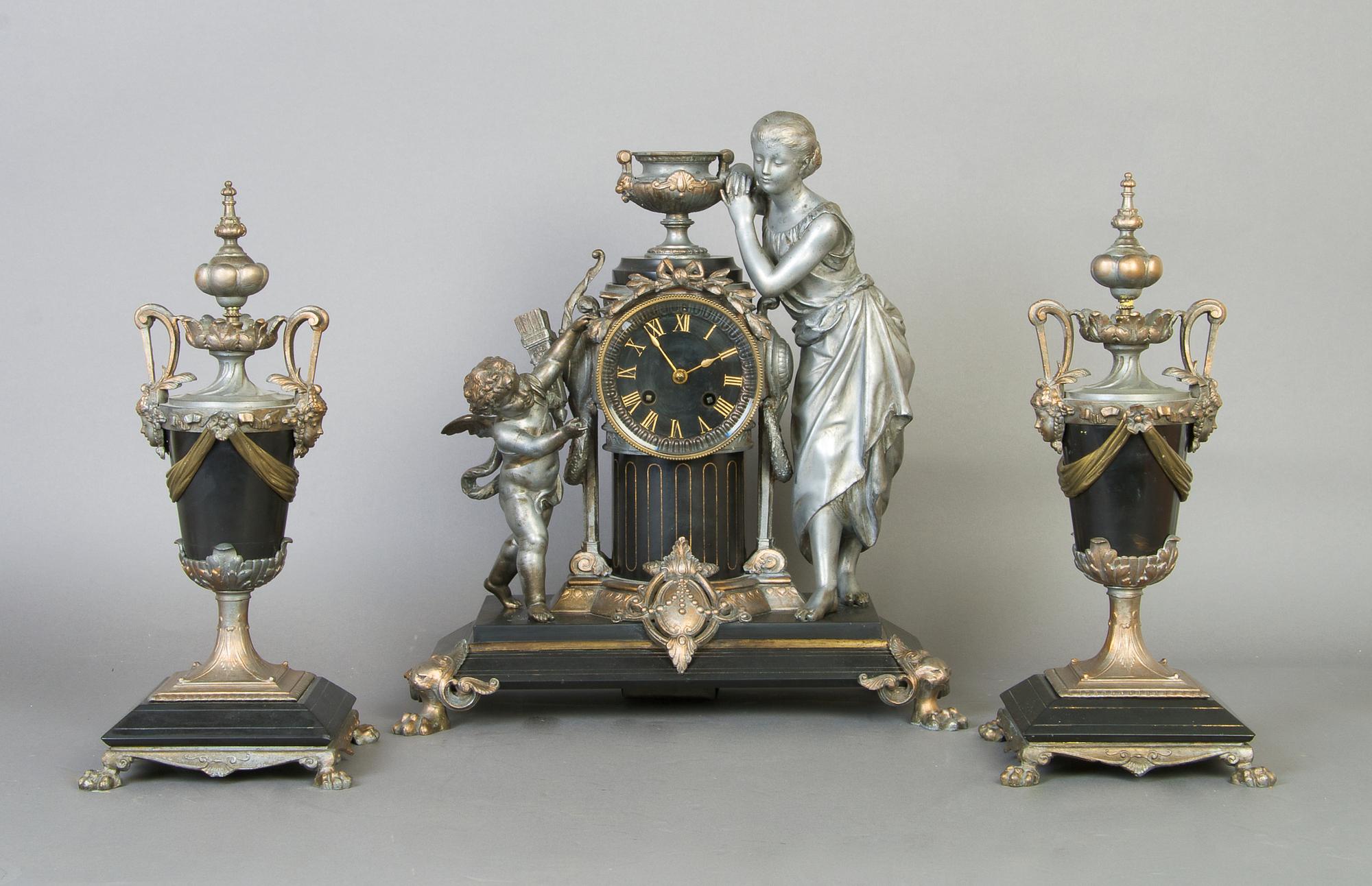 A Victorian Slate and Cast Metal Figural Clock Garniture, Height of clock 14 3/4 inches.