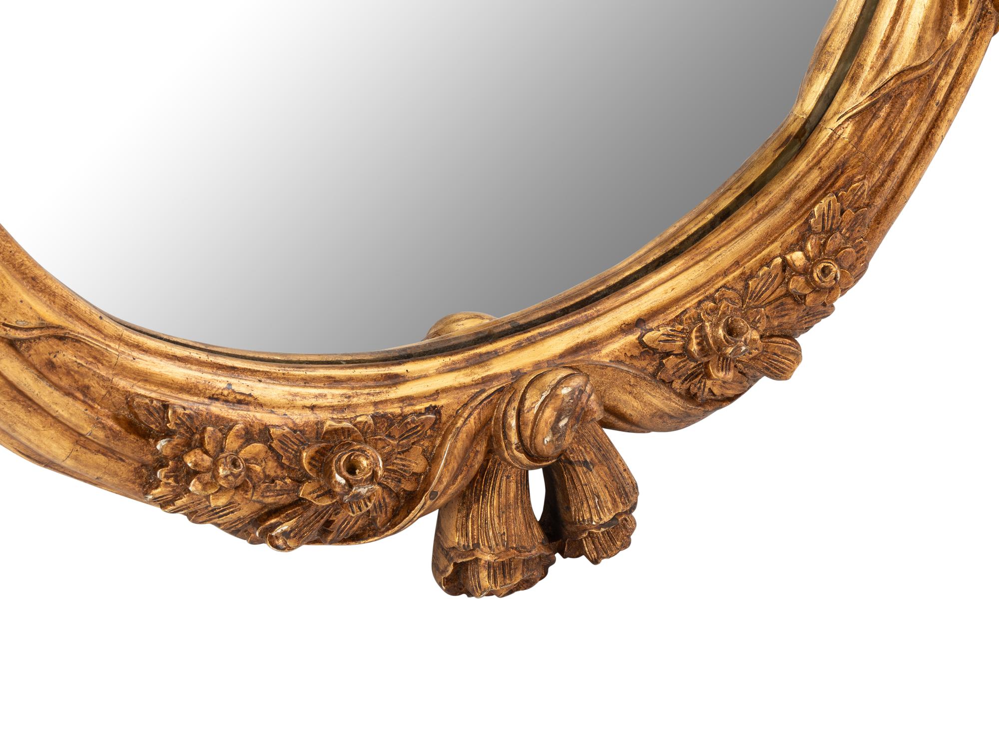 A Pair of Italian Carved Giltwood Oval Mirrors
