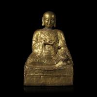 A Mongolian Gilt Copper Repoussé Figure of a Seated Luohan or Monk, 19th Century 清晚期 蒙古銅錘揲羅漢像