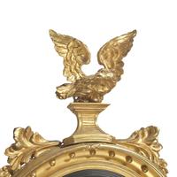 A Classical Giltwood and Parcel Ebonized Bull's Eye Mirror with Eagle