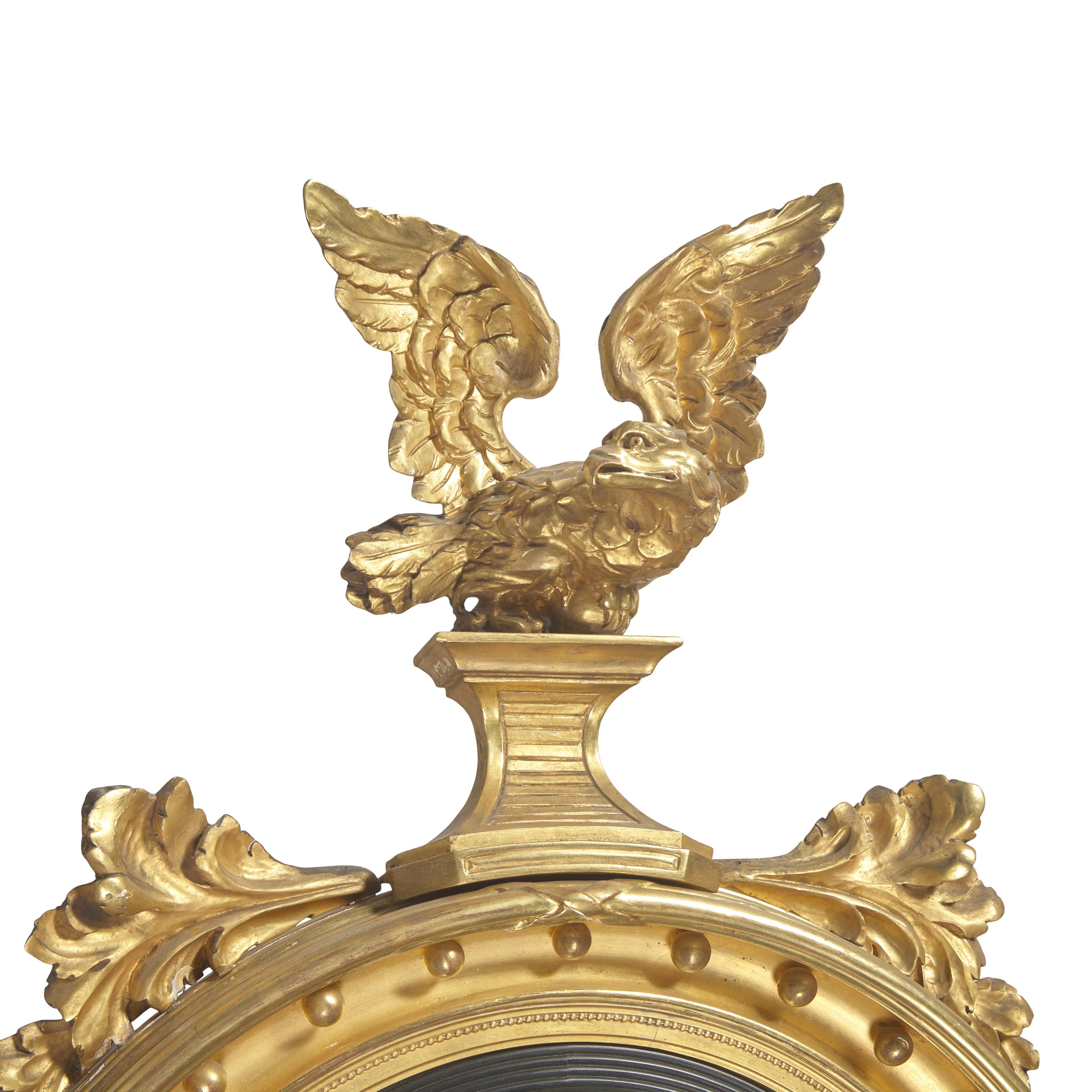 A Classical Giltwood and Parcel Ebonized Bull's Eye Mirror with Eagle