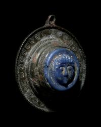 A Romano-Celtic Bronze and Blue Glass Fibula with a Mask