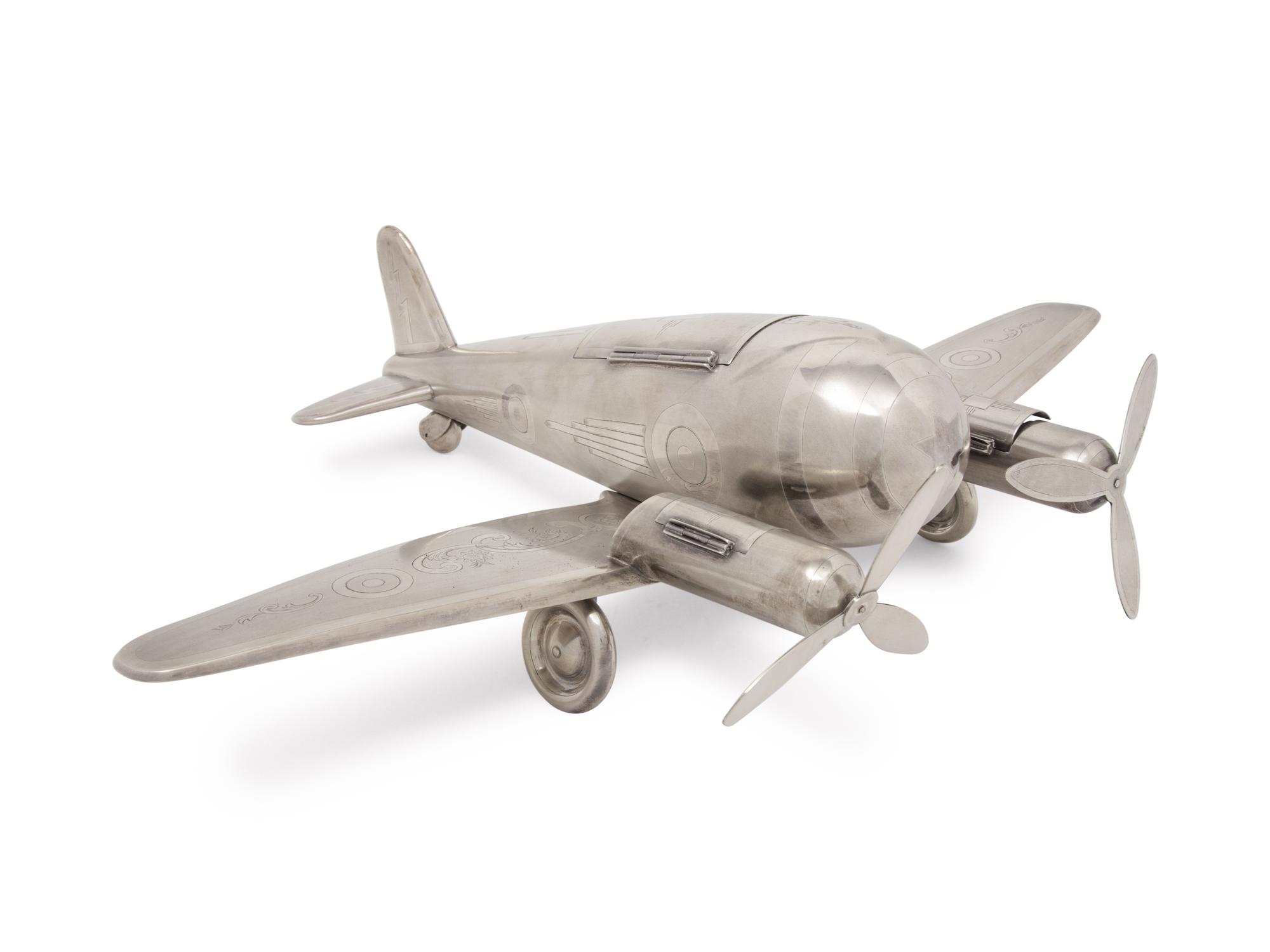 A Large Silvered Metal Airplane-Form Table Top Smoking Set