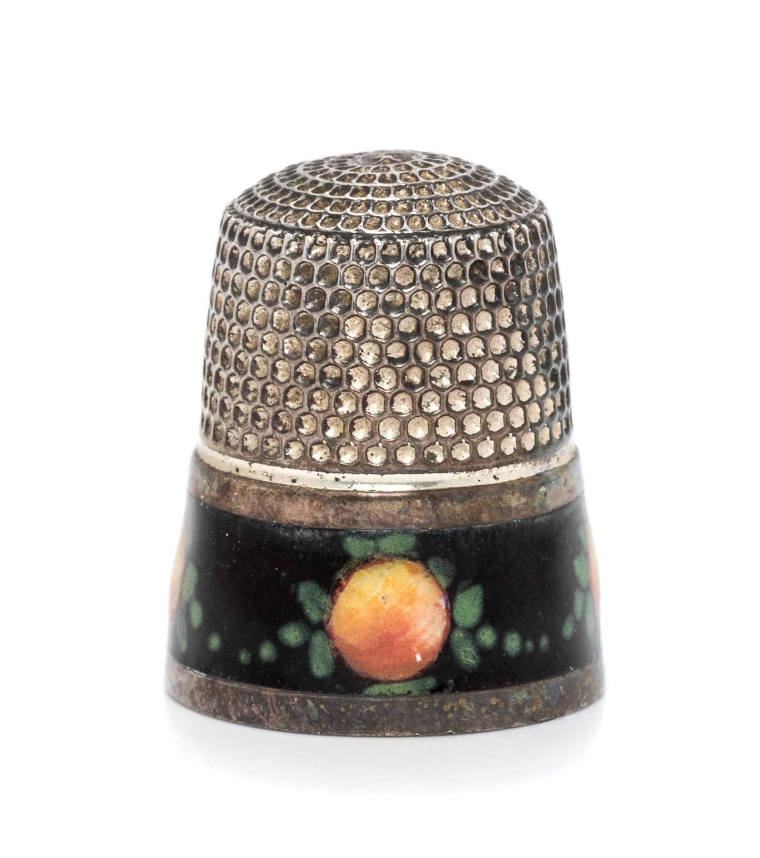 An American Silver and Enamel Thimble, , having a knurled top and body above a black enamel band decorated to show fruit and foliate de