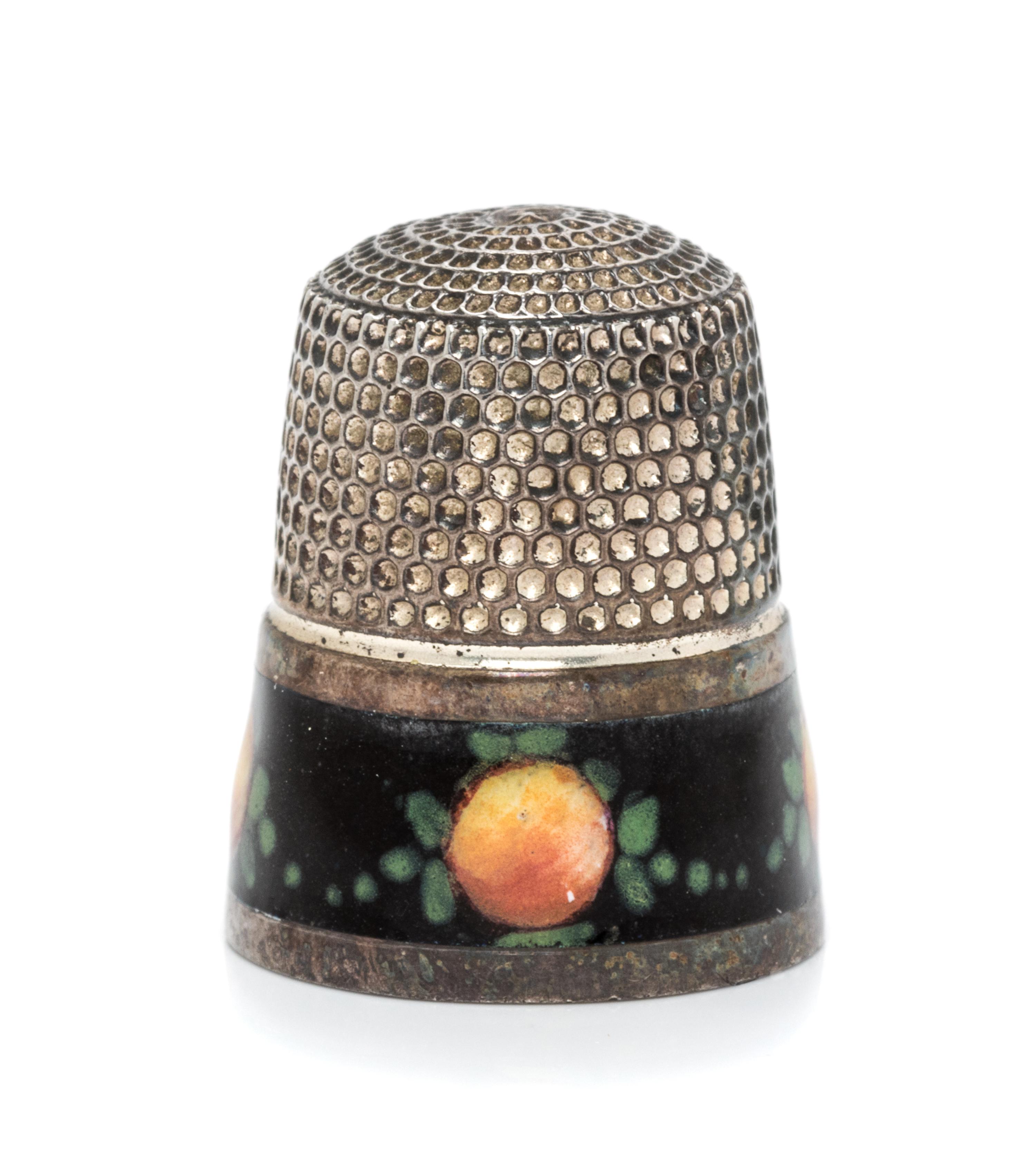 An American Silver and Enamel Thimble, , having a knurled top and body above a black enamel band decorated to show fruit and foliate de
