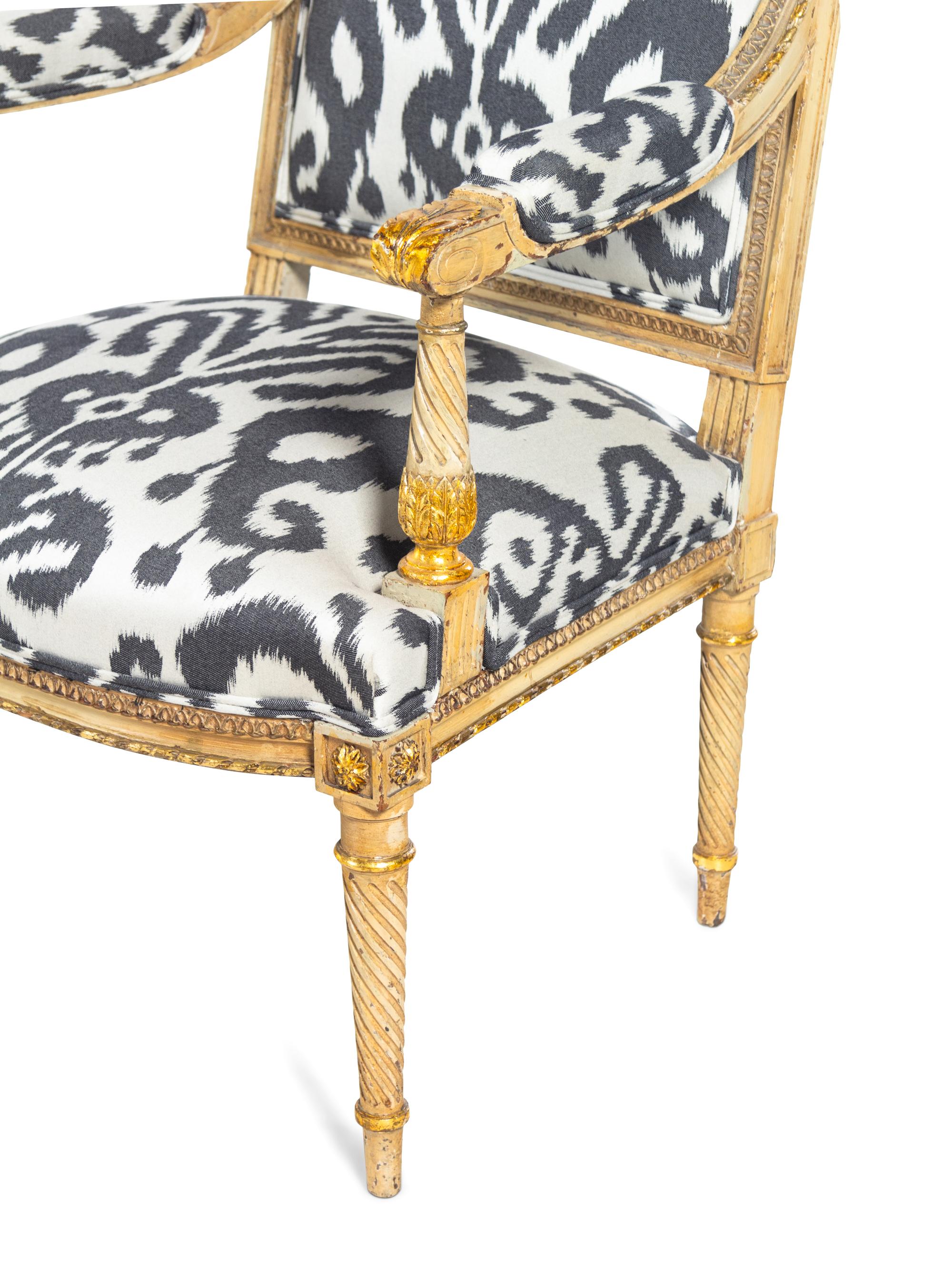 A Pair of Louis XVI Style Brunschwig & Fils Upholstered Cream-Painted and Parcel Gilt Fauteuils