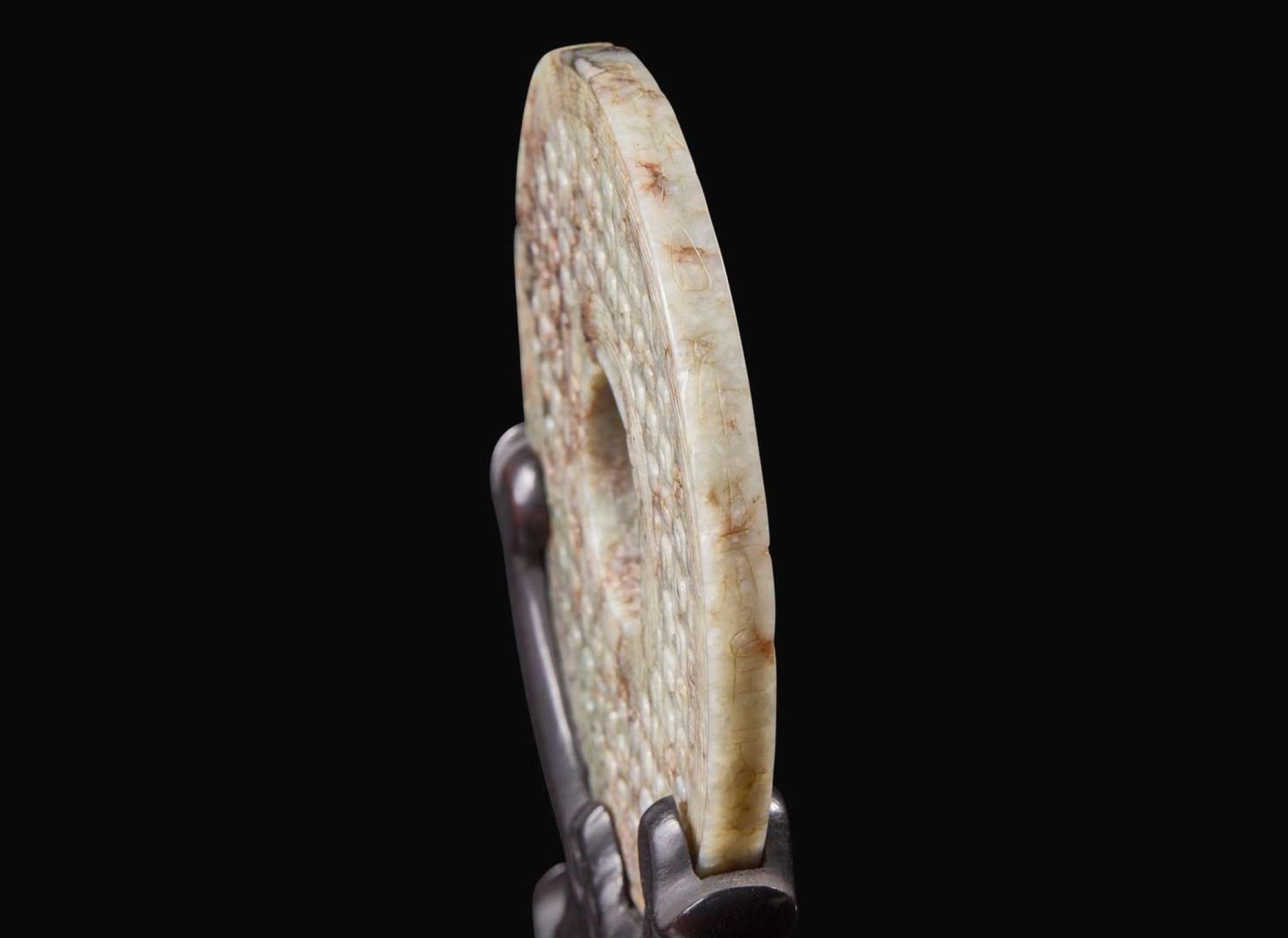 A Chinese archaistic carved mottled grey and russet jade bi disc 玉璧一件