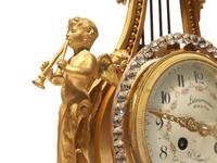 A Louis XVI Style Gilt Bronze and Pink Marble Three-Piece Clock Garniture