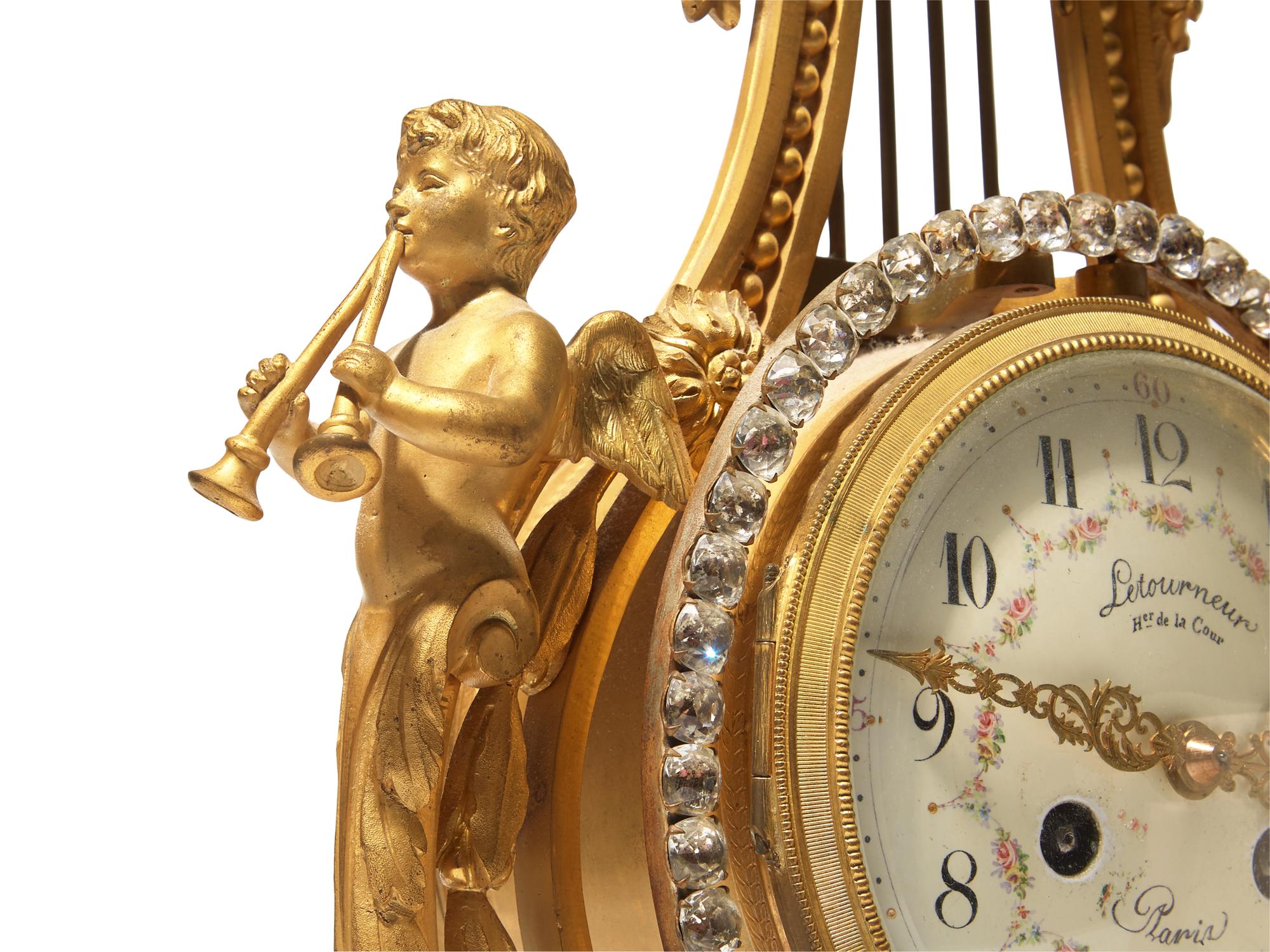 A Louis XVI Style Gilt Bronze and Pink Marble Three-Piece Clock Garniture