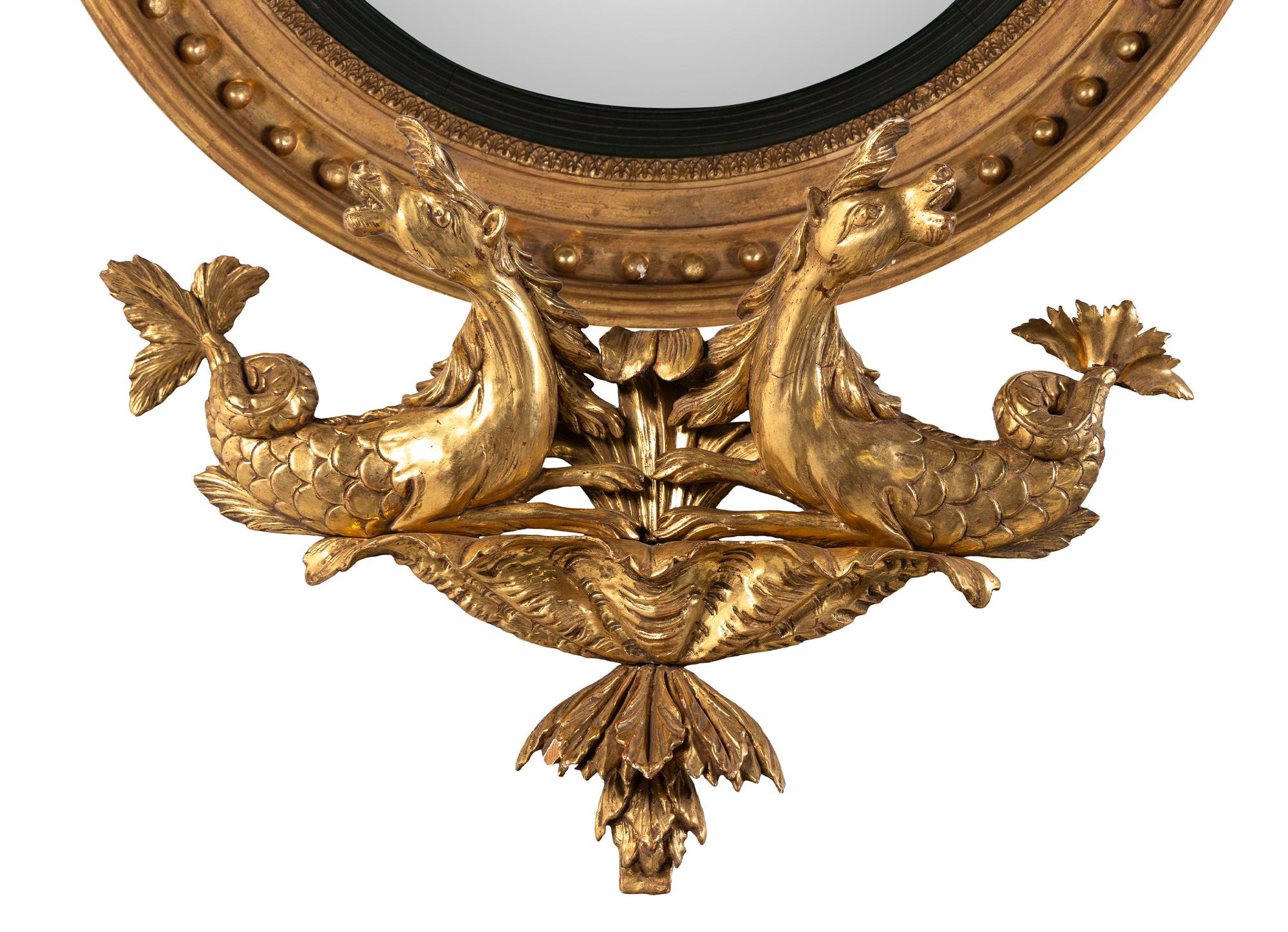 A Pair of Regency Carved Giltwood Convex Wall Mirrors