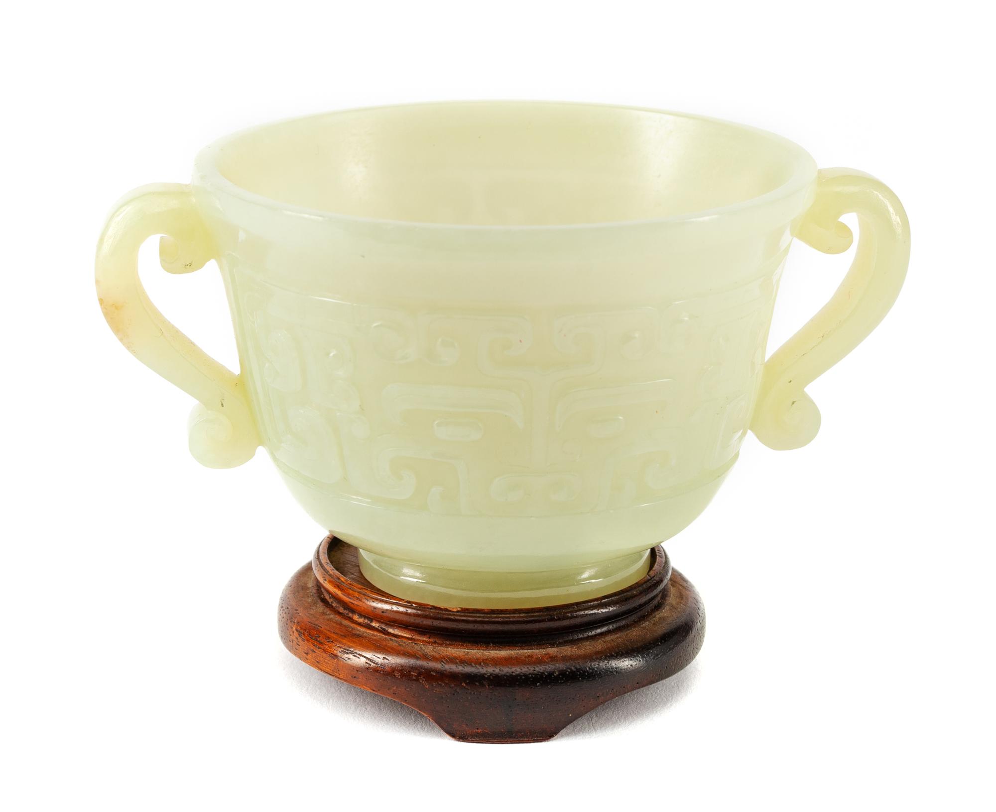 A Chinese Carved Jadeite Cup on a Wood Base