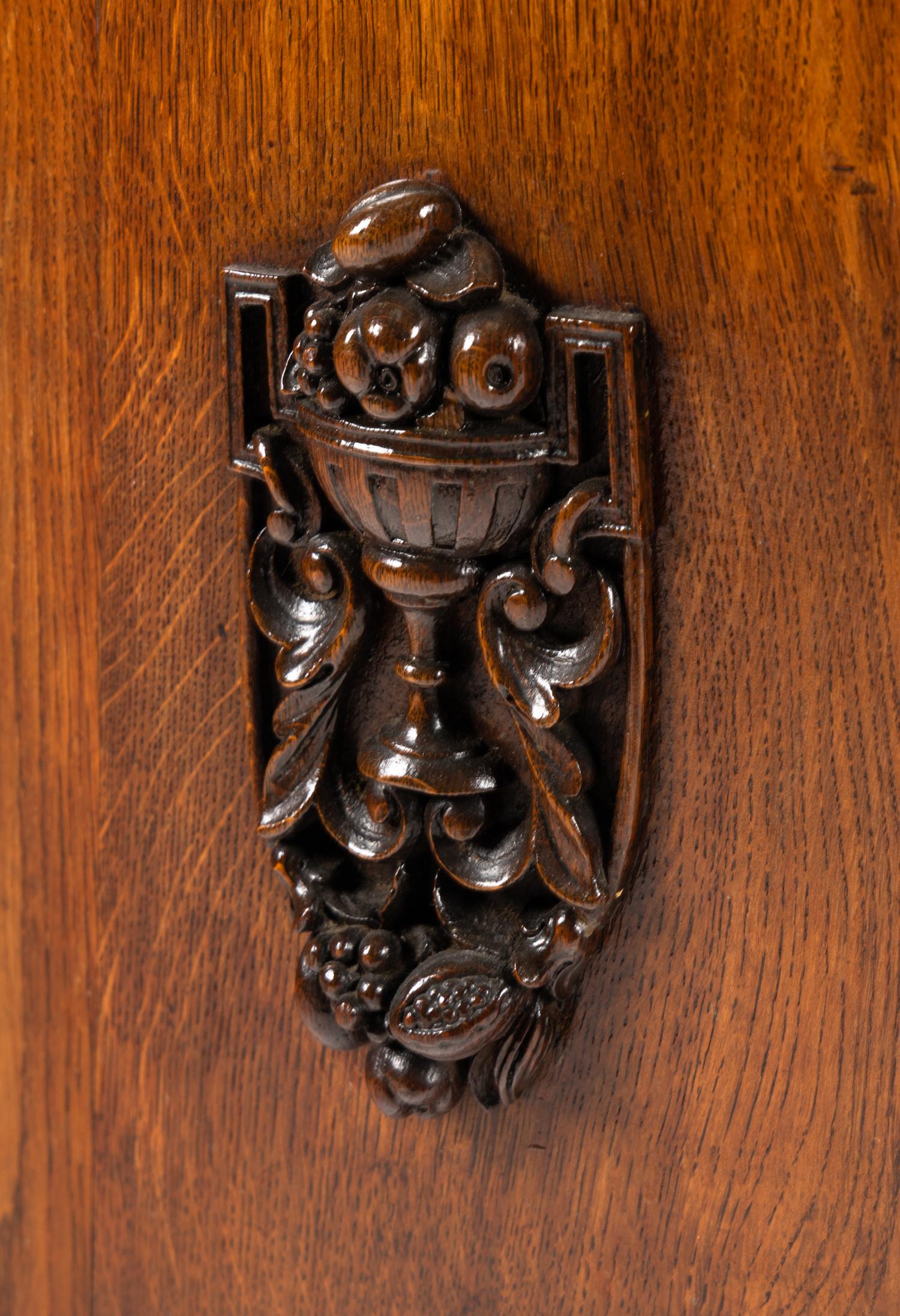 A Continental Carved Oak Demilune Cabinet