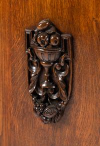 A Continental Carved Oak Demilune Cabinet