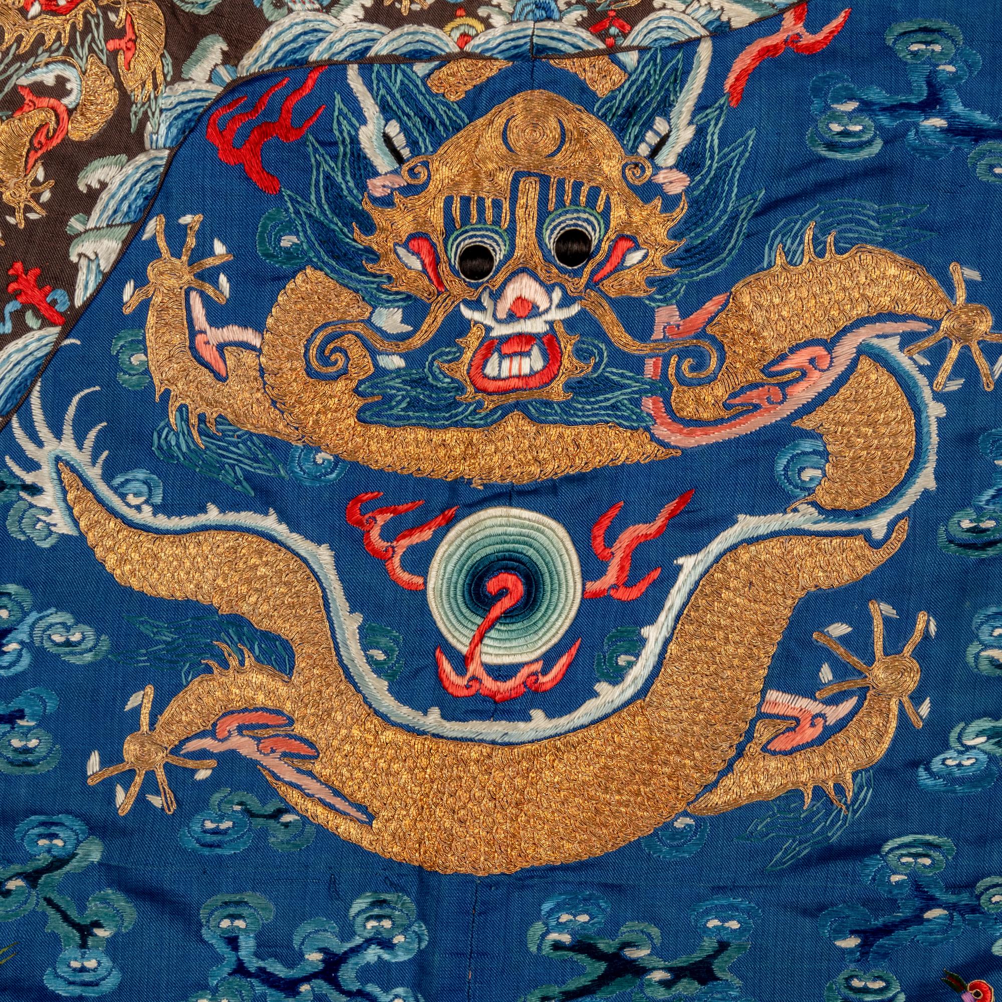 A Chinese Blue Ground Embroidered Silk 'Dragon' Robe, Jifu, 19th Century 清晚期 藍緞地綉云龍紋吉服