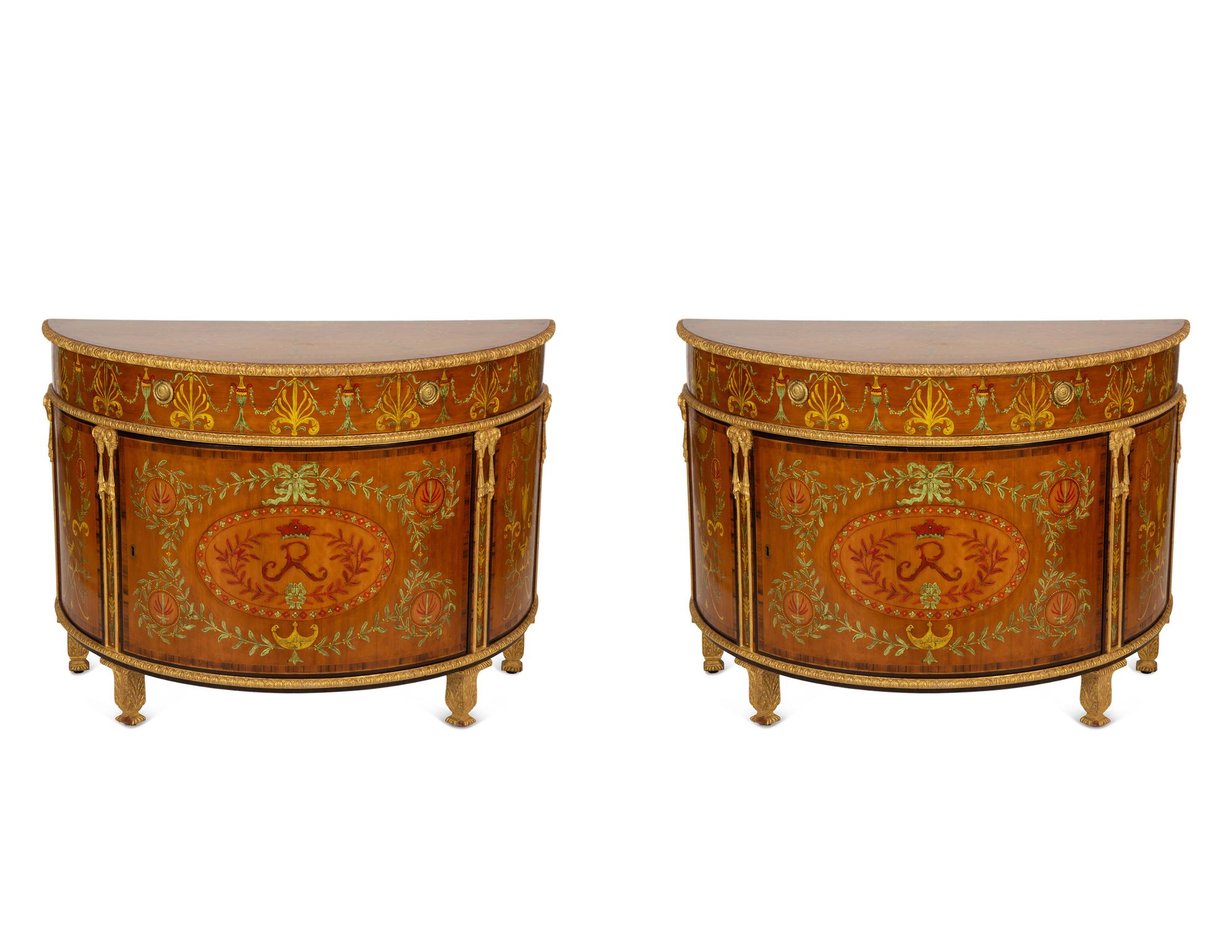A Pair of Adam Style Painted Parcel Gilt and Marquetry Inlaid Demilune Commodes