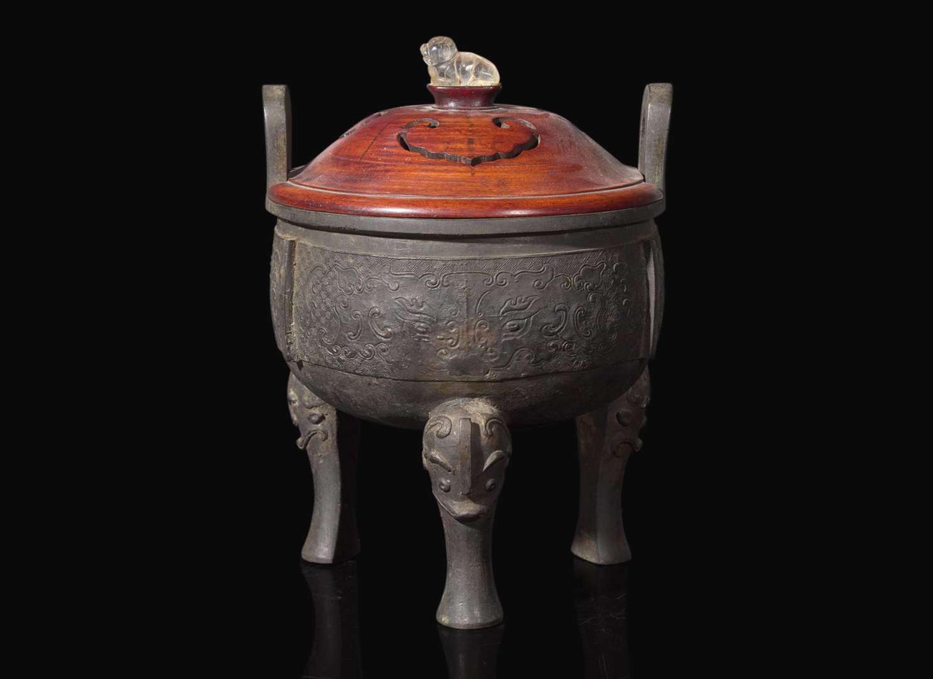 A large Chinese patinated bronze archaistic tripod censer, Ding, and wood cover, The Bronze 17th/18th Century or Earlier 清 青銅鼎式爐