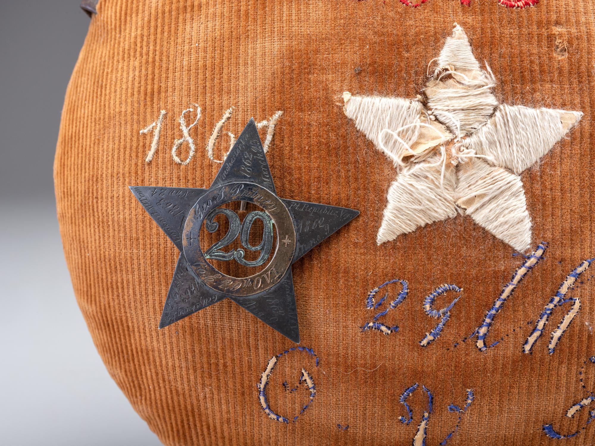 [CIVIL WAR]. A group of 3 items identified to George J. Putney, Company E, 29th Ohio Infantry, comprised of a silver corps badge engraved with battle honors, embellished canteen, and book taken from wreckage at Bristoe Station.