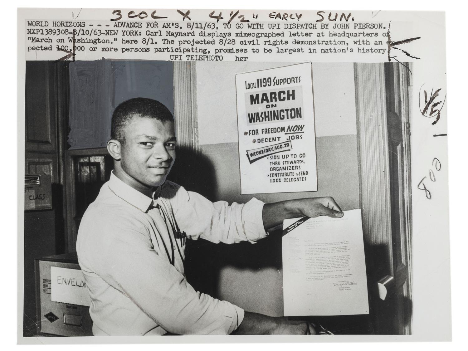 [CIVIL RIGHTS]. Press photograph of Carl Maynard, a young African American at the March on Washington headquarters, posed with letter and poster promoting the upcoming demonstration. New York, 11 August 1963.