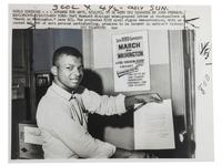 [CIVIL RIGHTS]. Press photograph of Carl Maynard, a young African American at the March on Washington headquarters, posed with letter and poster promoting the upcoming demonstration. New York, 11 August 1963.