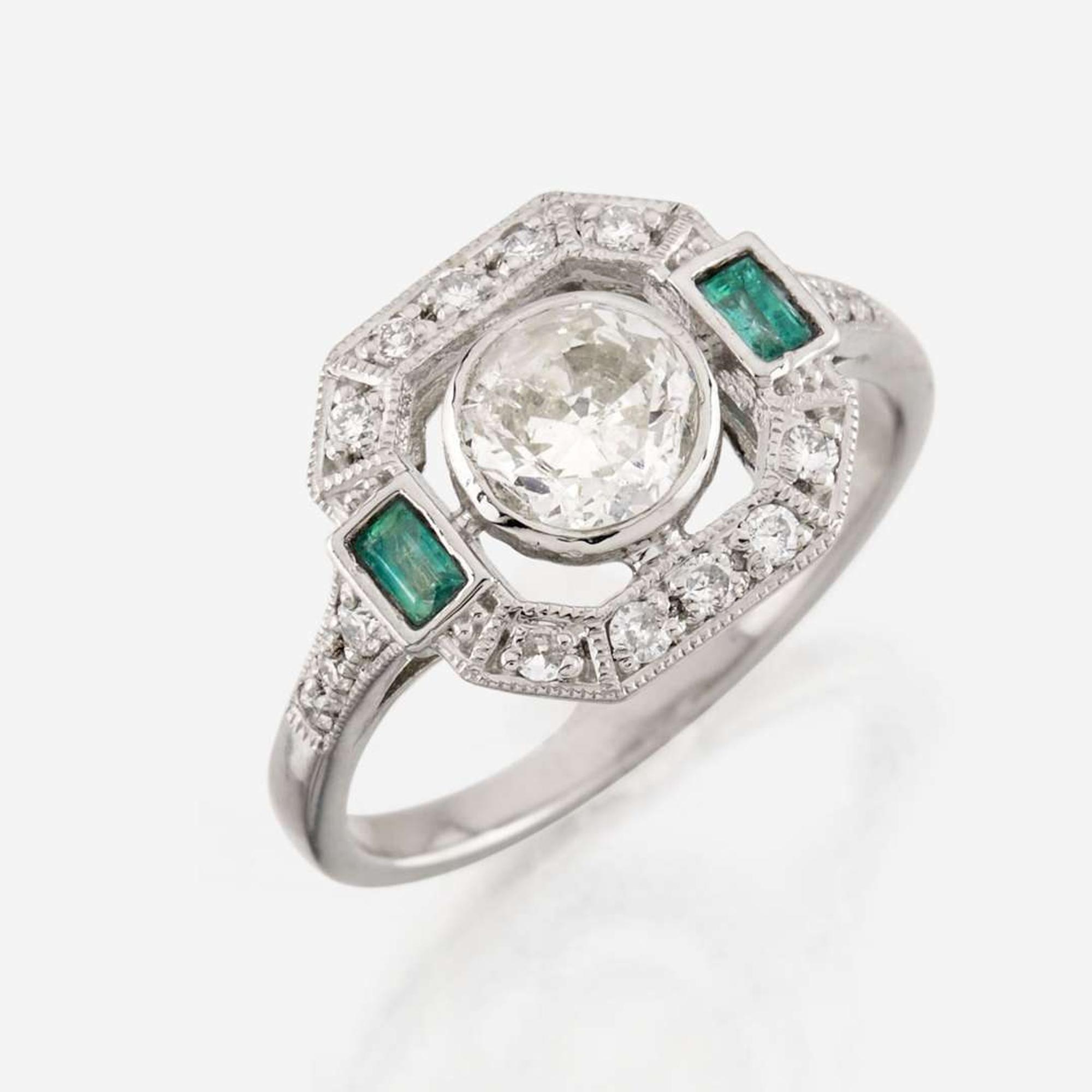 A diamond, emerald, and platinum ring