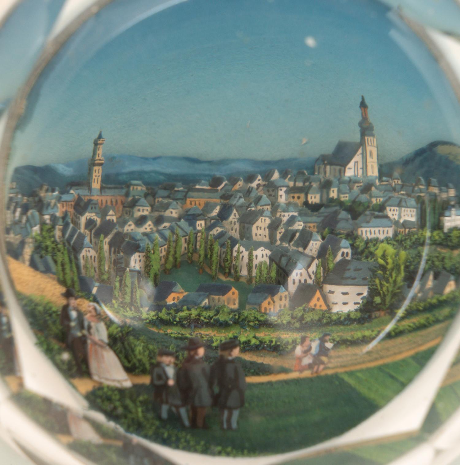 A Village Scene Diorama Faceted Glass Paperweight and a Commemorative Glass Paperweight
