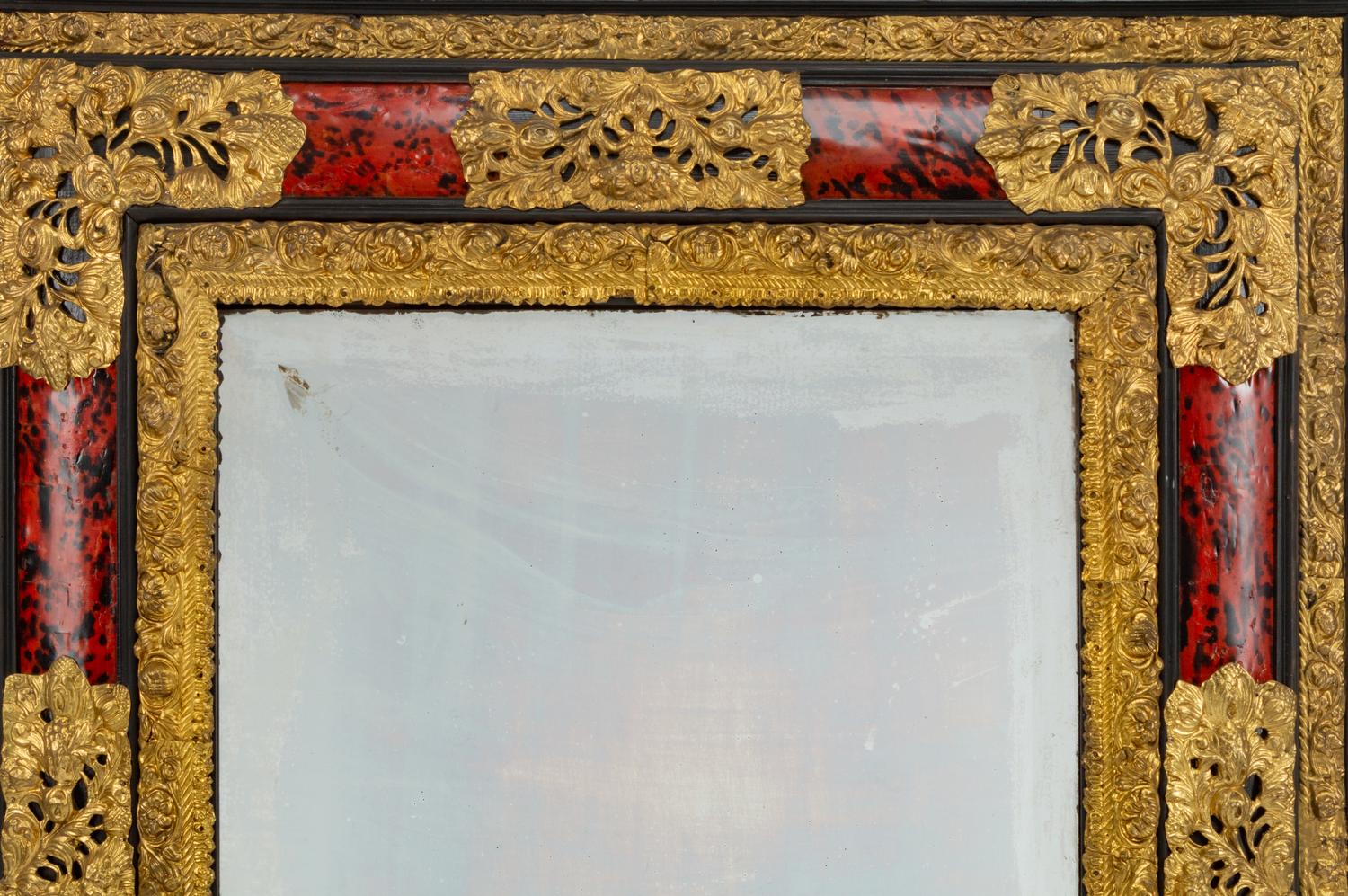 A Flemish Baroque Style Repouséed Brass, Simulated Tortoise and Ebonized Wood Mirror