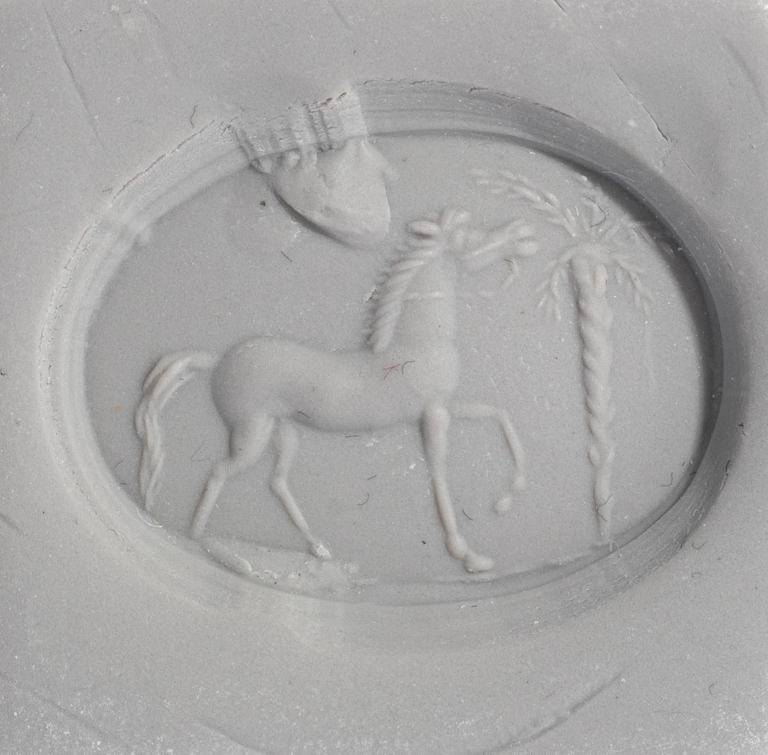 A Roman Bloodstone Ring Stone with a Horse and Palm Tree